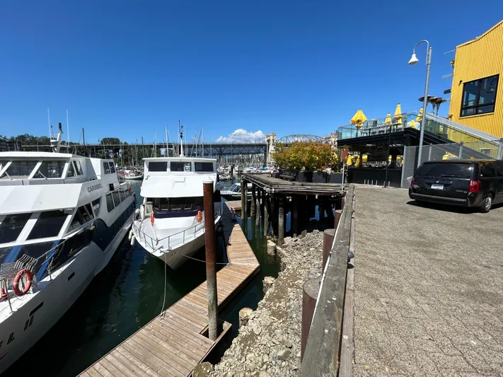 Eloquent Yacht Photos Pics Docked Palmer Marine 70 Pilothouse yacht, 1990 model, near waterfront restaurant and parked car.