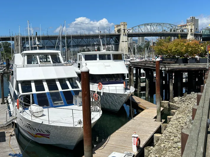 Eloquent Yacht Photos Pics Two Palmer Marine 70 Pilothouse yachts docked near a bridge, sunny day, 1990 model.