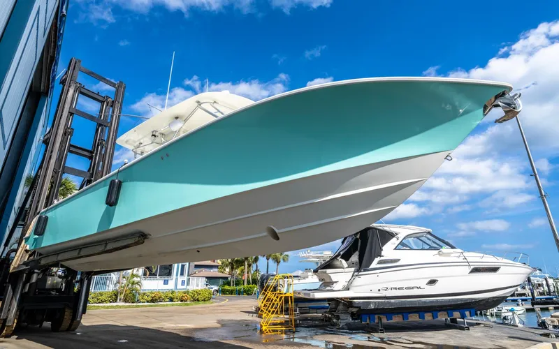 Liquid Asset Yacht Photos Pics 2012 SeaVee 39 LE boat lifted at marina, clear blue sky background.