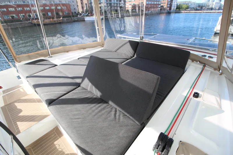 Vela Yacht Photos Pics Luxurious seating area on a 2021 Lagoon 46 catamaran, overlooking a scenic waterfront.