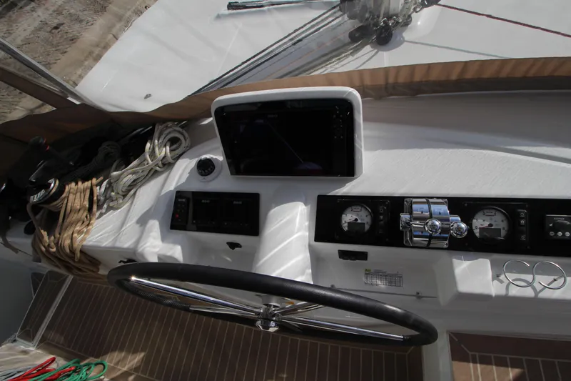 Vela Yacht Photos Pics Cockpit of 2021 Lagoon 46 catamaran with steering wheel and navigation instruments.