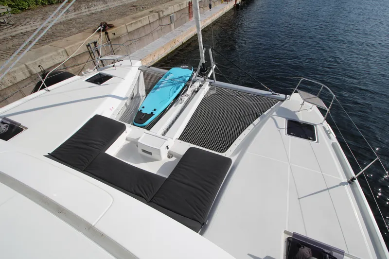 Vela Yacht Photos Pics 2021 Lagoon 46 catamaran with deck view, featuring sunbathing area and paddleboard.