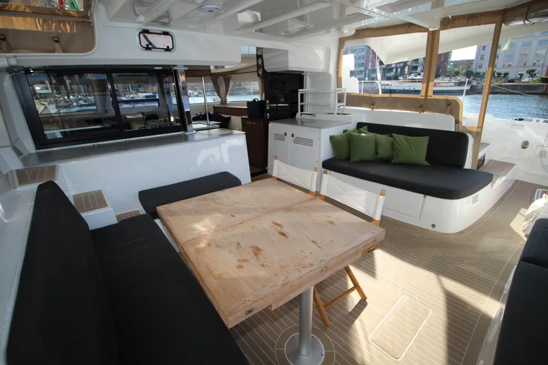 Vela Yacht Photos Pics Spacious interior of 2021 Lagoon 46 catamaran with seating and dining area.