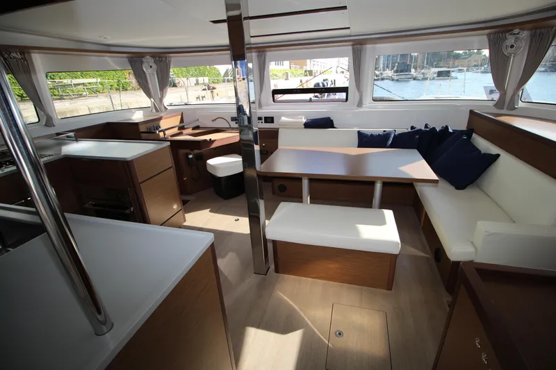 Vela Yacht Photos Pics Spacious interior of 2021 Lagoon 46 catamaran with modern seating and large windows.
