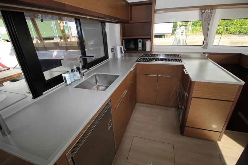 Vela Yacht Photos Pics Modern kitchen interior of 2021 Lagoon 46 catamaran with sleek countertops and appliances.