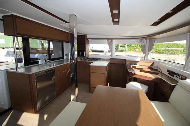 Vela Yacht Photos Pics Luxurious interior of 2021 Lagoon 46 catamaran with modern kitchen and dining area.