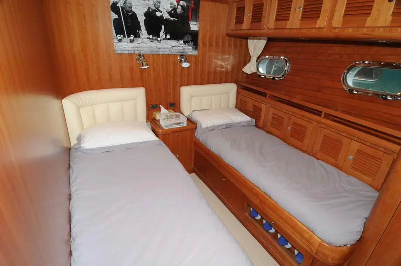 Yacht Photos Pics Luxurious twin cabin in 2026 Selene 62 yacht with wood paneling and portholes.