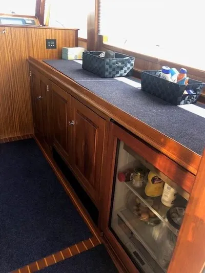 Moses Yacht Photos Pics 2003 Lyman-Morse Wesmac Sportfish Cruiser interior with wooden cabinetry and mini fridge.