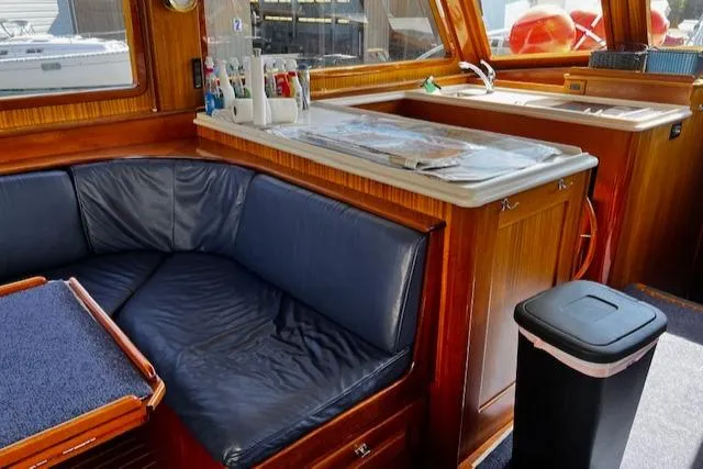 Moses Yacht Photos Pics 2003 Lyman-Morse Wesmac Sportfish Cruiser interior with blue seating and wooden cabinetry.