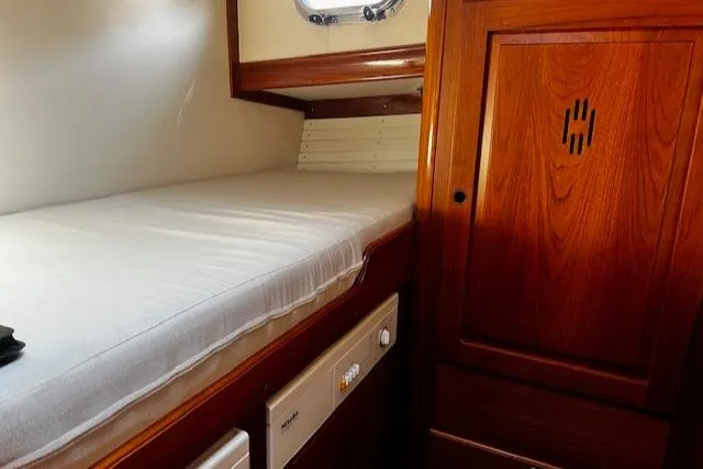 Moses Yacht Photos Pics Cabin interior of 2003 Lyman-Morse Wesmac Sportfish Cruiser with wooden cabinetry and a single bed.