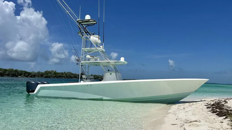 Nauty C Bouys Yacht Photos Pics 2012 Contender 39 ST boat on a sandy beach with clear blue water and sky.