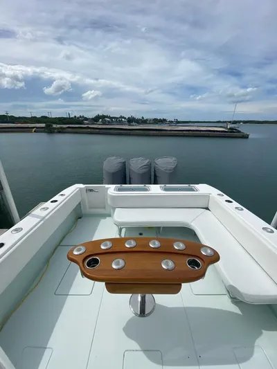 Nauty C Bouys Yacht Photos Pics 2012 Contender 39 ST boat with wooden rod holder, docked by calm waters.