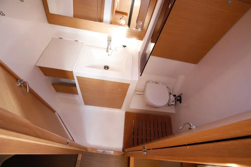 Cum Laude Yacht Photos Pics Bathroom interior of 2017 Dufour 512 Grand Large yacht, featuring modern fixtures and wood accents.