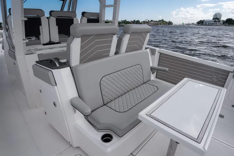  Yacht Photos Pics 2022 Pursuit S 428 Sport boat interior with luxurious seating and table by the water.