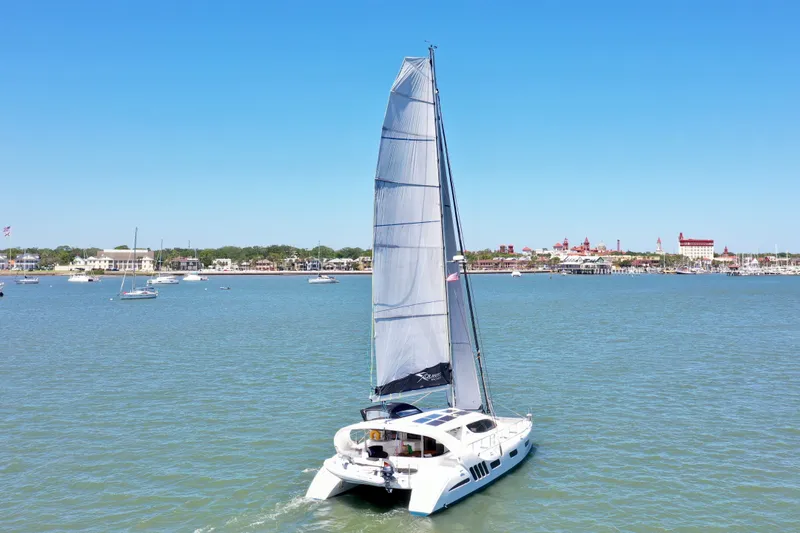 Fido Yacht Photos Pics 2017 Xquisite Yachts X5 catamaran sailing on a calm sea under a clear blue sky.