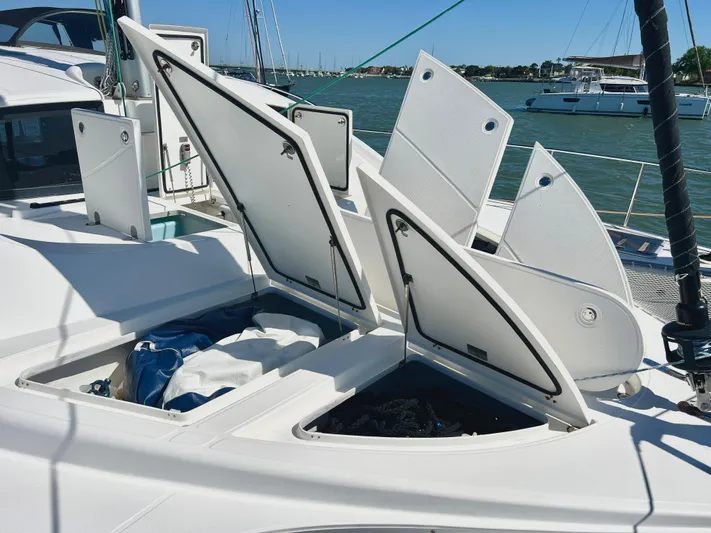 Fido Yacht Photos Pics 2017 Xquisite Yachts X5 deck with open storage compartments, docked in a marina.