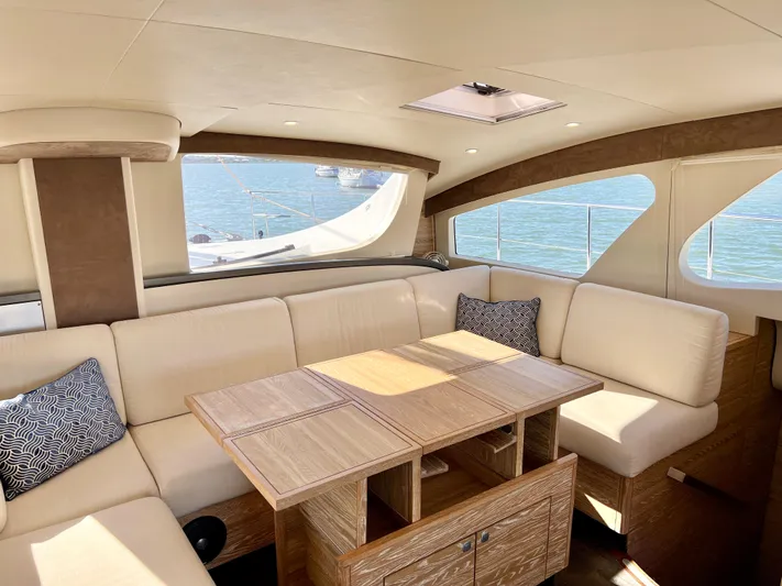 Fido Yacht Photos Pics Luxurious interior of 2017 Xquisite Yachts X5 with elegant seating and wooden table.