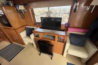 Interior of 2008 Beneteau Swift Trawler 52 with cozy seating and TV setup.