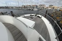 2008 Beneteau Swift Trawler 52 docked in a marina, showcasing spacious deck and harbor view.