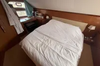 Cozy bedroom in 2008 Beneteau Swift Trawler 52 with wooden accents and natural light.