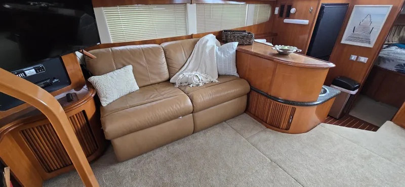 Live Now Yacht Photos Pics Interior of 2006 Carver 44CPMY yacht with leather sofa and wooden cabinetry.