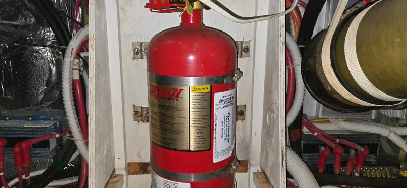 Live Now Yacht Photos Pics Fire extinguisher in 2006 Carver 44CPMY engine room, surrounded by wiring and hoses.