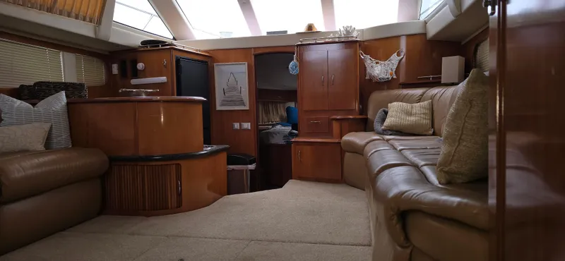 Live Now Yacht Photos Pics Interior of 2006 Carver 44CPMY yacht with luxurious seating and wood cabinetry.