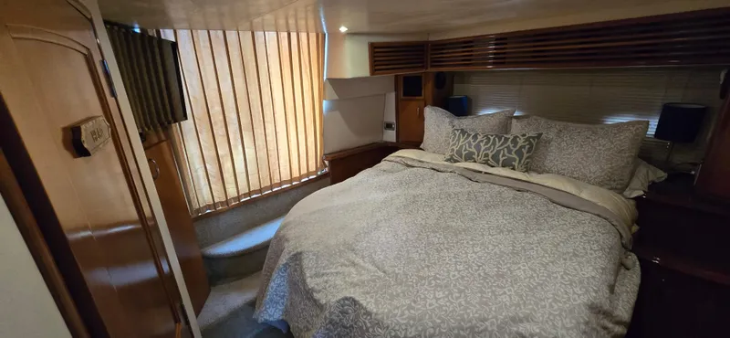 Live Now Yacht Photos Pics Luxurious bedroom interior of 2006 Carver 44CPMY yacht with cozy bedding and elegant decor.