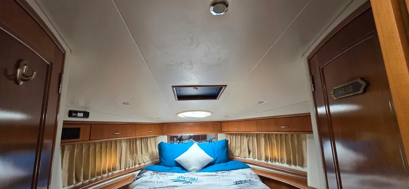 Live Now Yacht Photos Pics Luxurious 2006 Carver 44CPMY yacht bedroom with cozy bedding and elegant wood finishes.