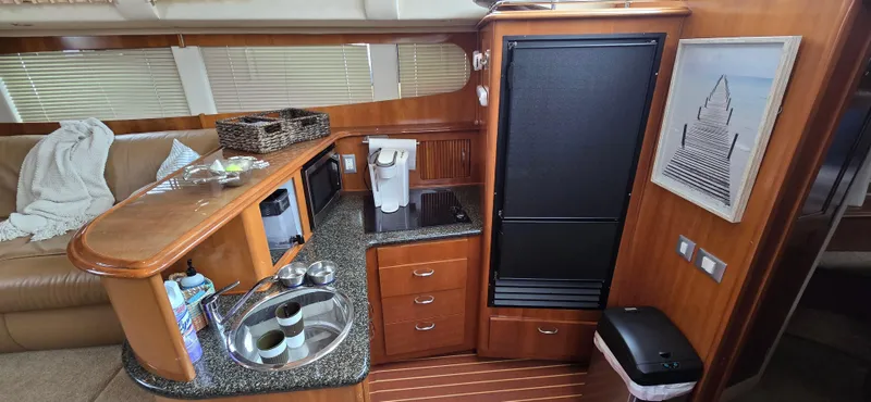 Live Now Yacht Photos Pics Interior of 2006 Carver 44CPMY yacht with kitchenette and seating area.