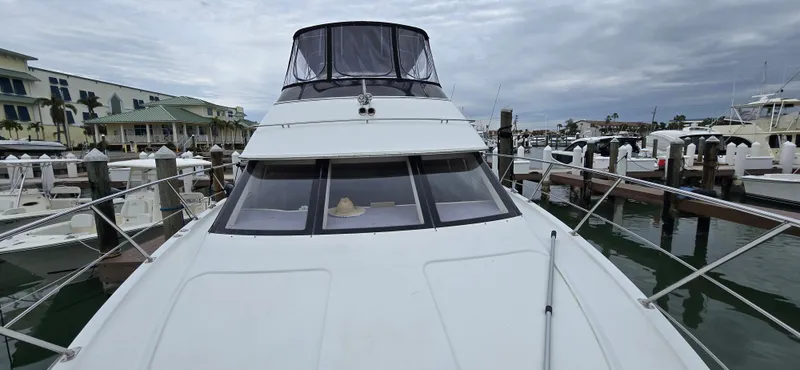 Live Now Yacht Photos Pics 2006 Carver 44CPMY yacht docked at marina under cloudy skies.