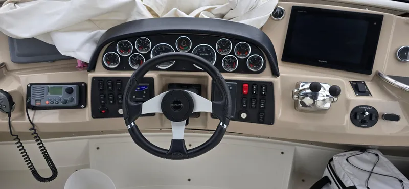 Live Now Yacht Photos Pics 2006 Carver 44CPMY helm with steering wheel, gauges, and navigation controls.