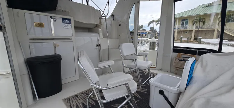 Live Now Yacht Photos Pics Interior of 2006 Carver 44CPMY yacht with chairs and storage cabinets.