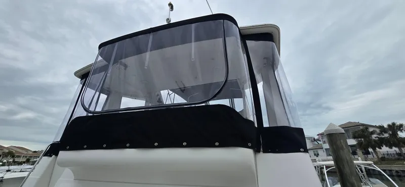 Live Now Yacht Photos Pics 2006 Carver 44CPMY yacht with enclosed flybridge, docked under cloudy skies.