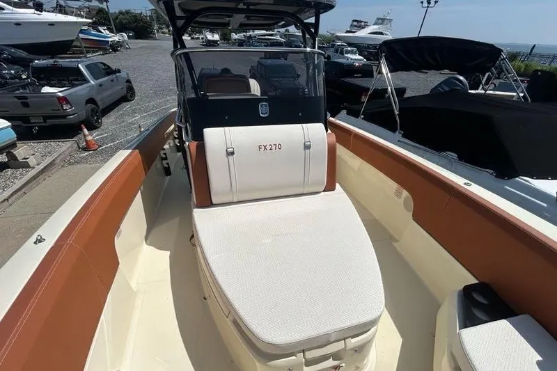  Yacht Photos Pics 2024 Capoforte FX270 boat interior, featuring spacious seating and modern design at a marina.