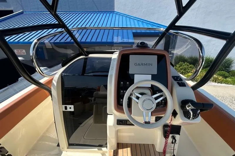  Yacht Photos Pics 2024 Capoforte FX270 boat helm with Garmin navigation system and modern steering wheel.