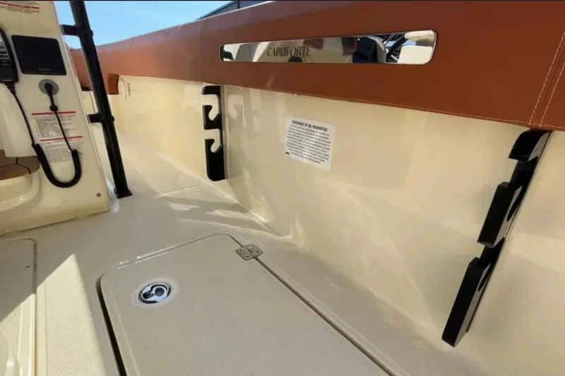  Yacht Photos Pics 2024 Capoforte FX270 boat interior with beige and brown accents, featuring storage compartments.