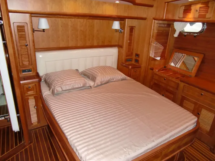  Yacht Photos Pics Luxurious wooden cabin interior of 2026 Selene 54 yacht with cozy bed and elegant decor.