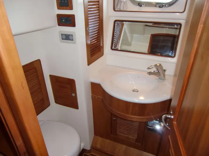  Yacht Photos Pics Luxury bathroom in 2026 Selene 54 yacht with wooden accents and modern fixtures.