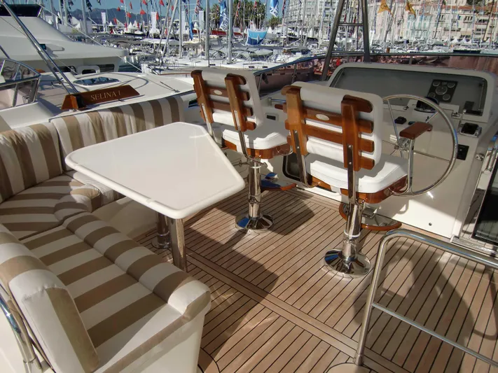  Yacht Photos Pics Luxurious Selene 54 yacht interior with striped seating, table, and helm, 2026 model.