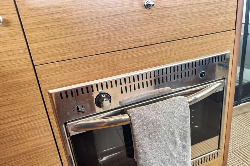 Sweet Sweet Life Yacht Photos Pics Wood-paneled oven in 2020 Lagoon 42 yacht kitchen with towel on handle.