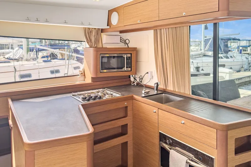 Sweet Sweet Life Yacht Photos Pics Modern kitchen interior of 2020 Lagoon 42 yacht with stove, sink, and microwave.