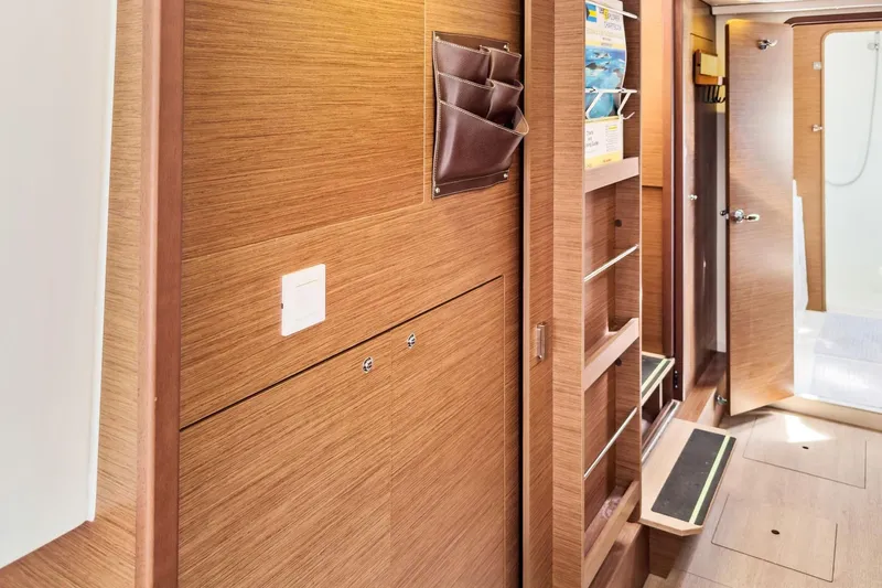 Sweet Sweet Life Yacht Photos Pics Interior of 2020 Lagoon 42 yacht featuring wooden cabinetry and open door to bathroom.
