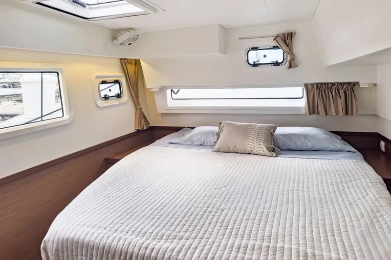 Sweet Sweet Life Yacht Photos Pics Luxurious cabin interior of 2020 Lagoon 42 catamaran with cozy bed and windows.