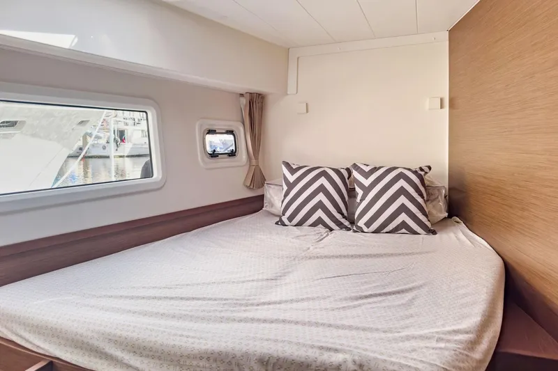 Sweet Sweet Life Yacht Photos Pics Cozy bedroom interior of 2020 Lagoon 42 yacht with chevron pillows and window view.