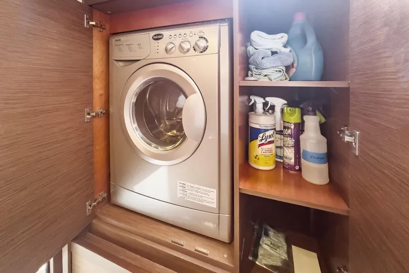 Sweet Sweet Life Yacht Photos Pics Laundry area on Lagoon 42 yacht, featuring a washing machine and cleaning supplies.