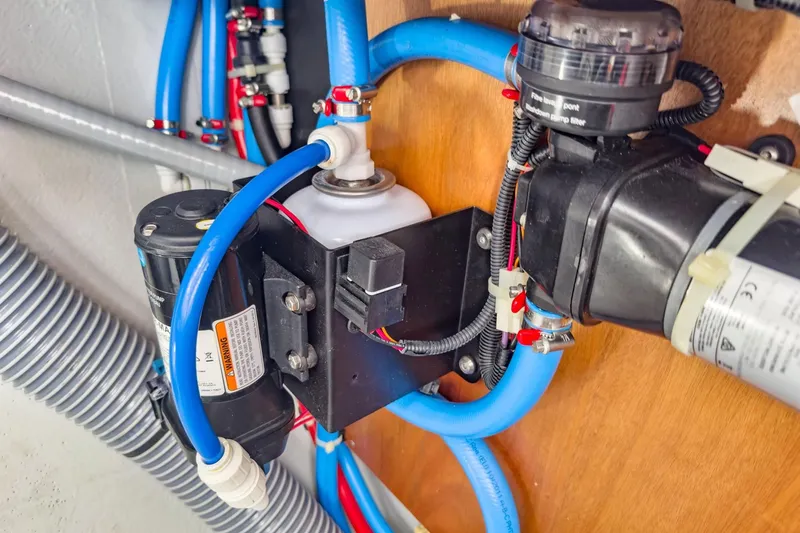 Sweet Sweet Life Yacht Photos Pics Electrical and plumbing system inside a 2020 Lagoon 42 yacht, featuring blue hoses and components.