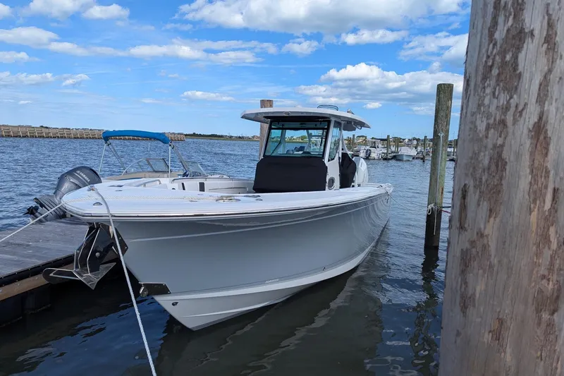  Yacht Photos Pics 2024 Blackfin 332 CC boat docked at marina under blue sky.