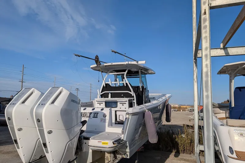  Yacht Photos Pics 2024 Blackfin 332 CC boat with dual Mercury engines, docked under clear blue sky.
