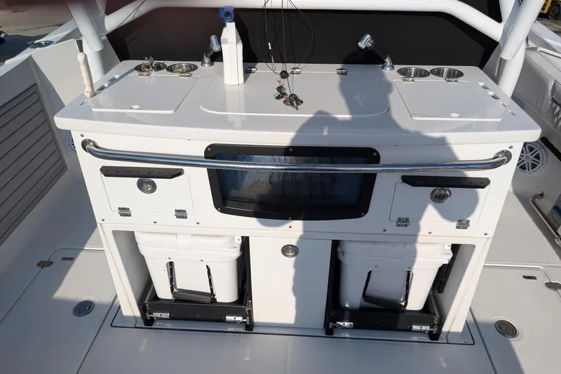  Yacht Photos Pics 2024 Blackfin 332 CC boat console with storage compartments and fishing equipment.